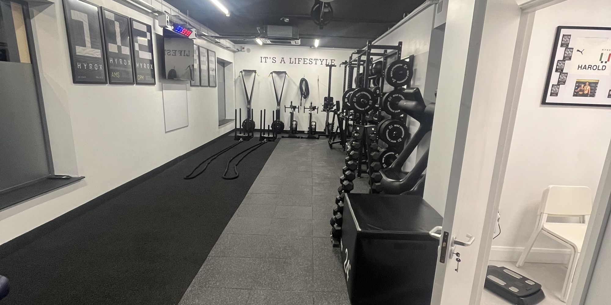 The length of the studio floor, matting running between racks to the far wall